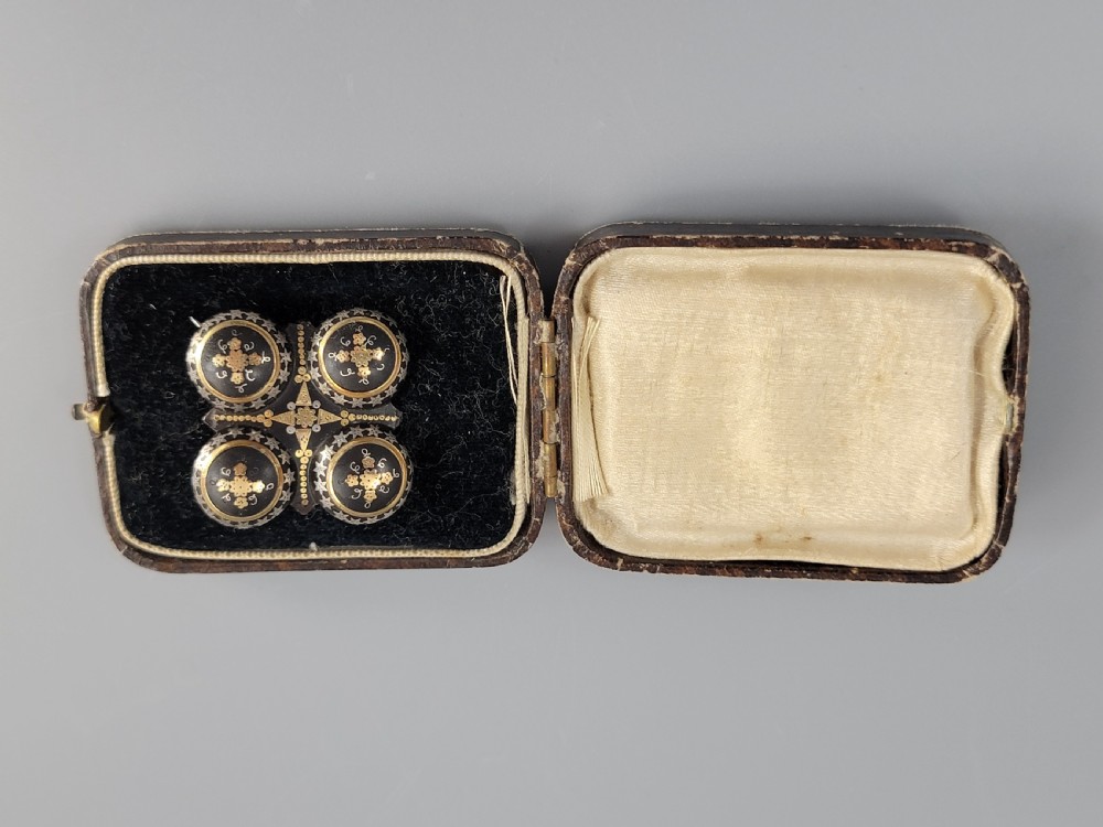 A Victorian quatrefoil brooch crafted from dark tortoiseshell with gold and silver pique work inlay set inside a fitted plush-lined box. View II
