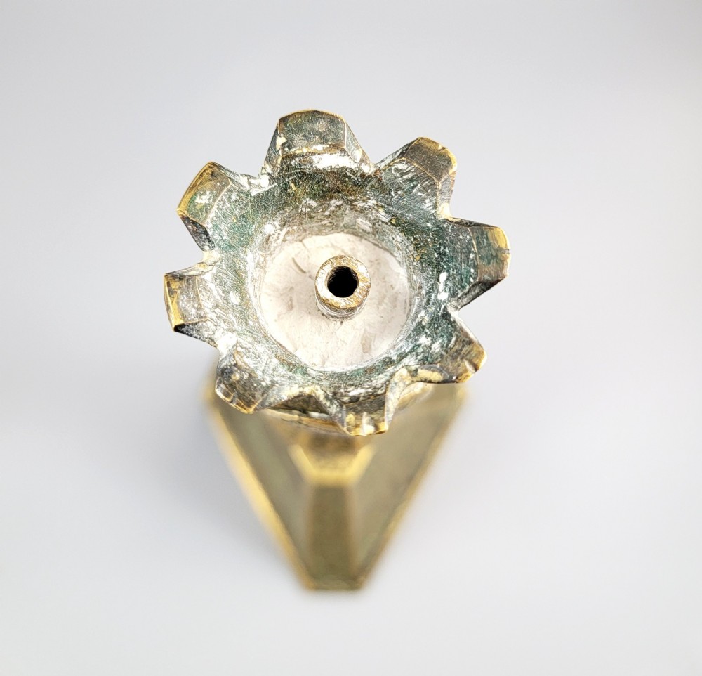 A tall late 19th-century Qajar Persian brass candlestick featuring a wide triangular engraved base, a knopped stem, and a flared lotus socket. View XV