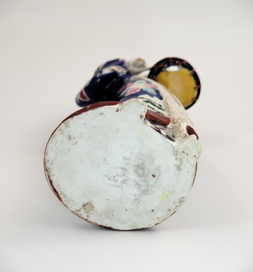 Japanese Kutani porcelain figurine of a standing lady in a cobalt blue floral kimono playing a hand drum. View VI