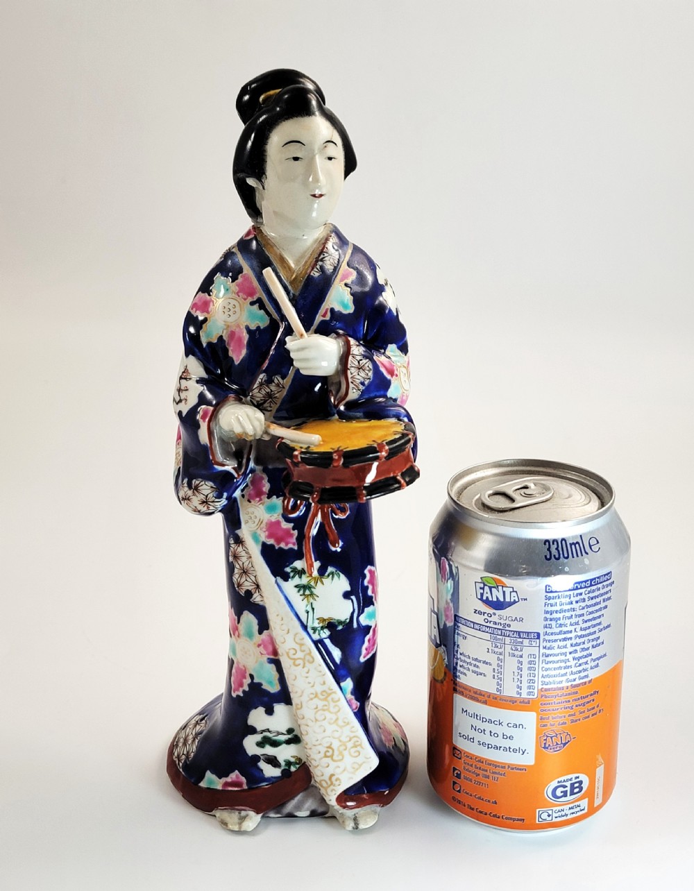 Japanese Kutani porcelain figurine of a standing lady in a cobalt blue floral kimono playing a hand drum. View X