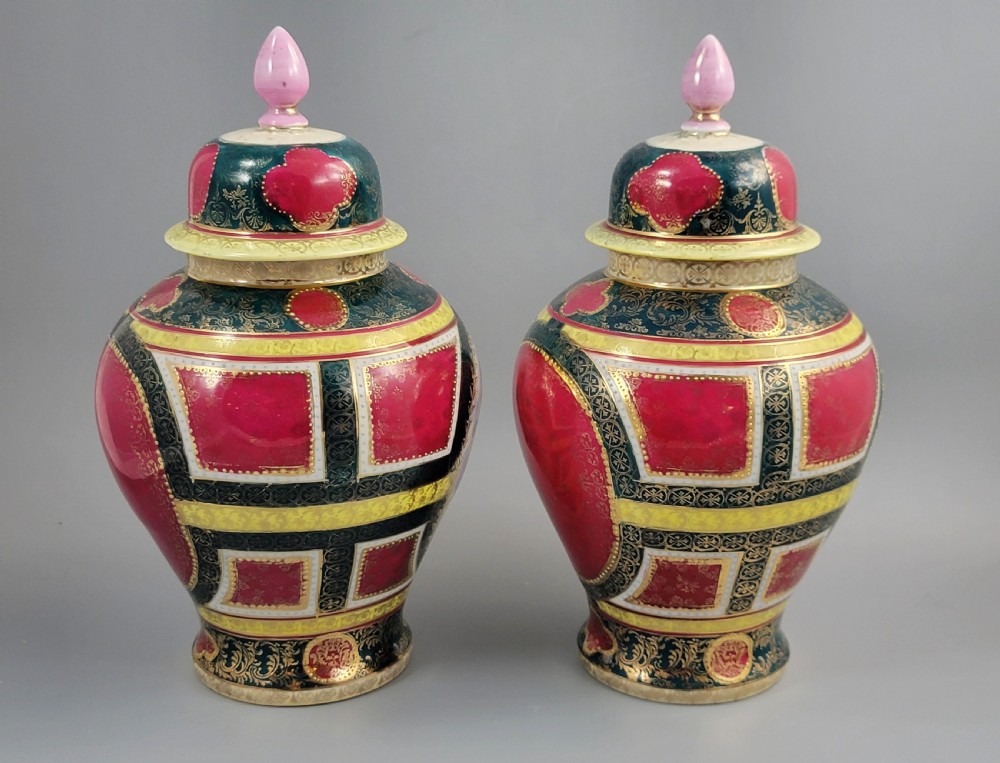 A pair of nineteenth-century Royal Vienna style porcelain covered urns featuring hand-painted classical figures inside oval gilt reserves, set against teal, pink, and yellow enamelled grounds. View V