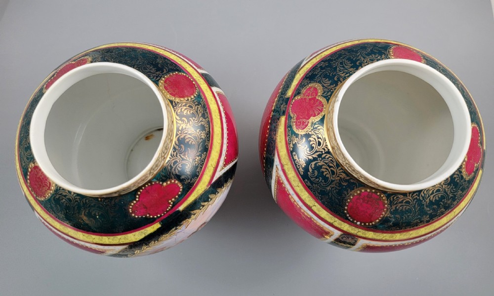 A pair of nineteenth-century Royal Vienna style porcelain covered urns featuring hand-painted classical figures inside oval gilt reserves, set against teal, pink, and yellow enamelled grounds. View VII