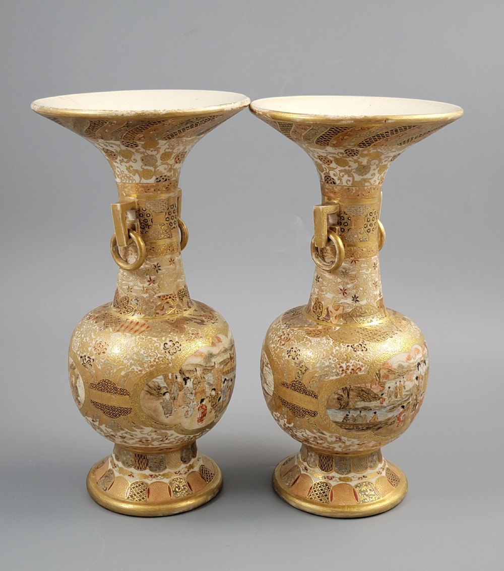 A pair of Japanese Satsuma earthenware vases featuring flared rims, fixed ring handles, and detailed hand-painted figural panels with extensive gold gilding. View IV