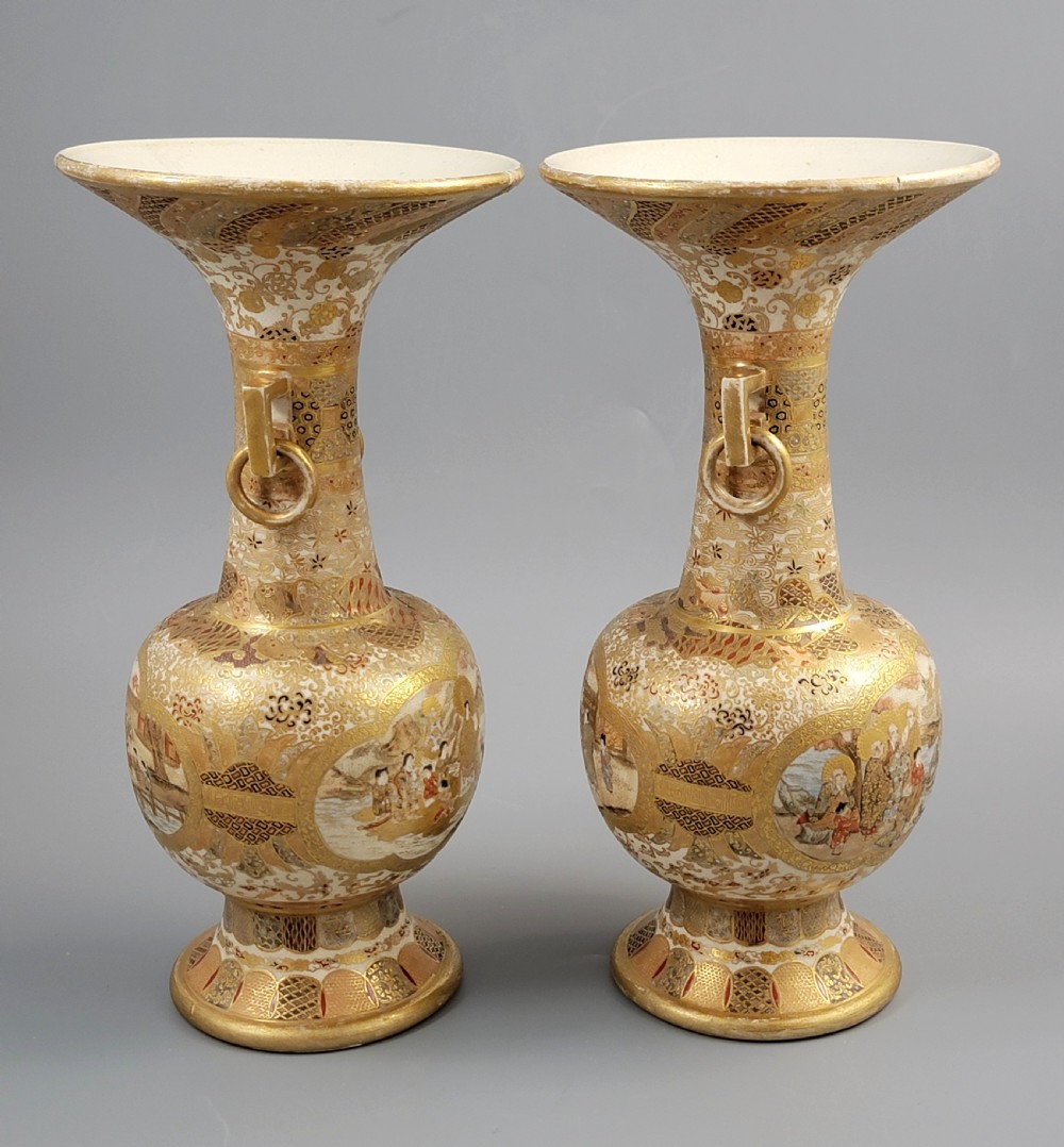 A pair of Japanese Satsuma earthenware vases featuring flared rims, fixed ring handles, and detailed hand-painted figural panels with extensive gold gilding. View VIII
