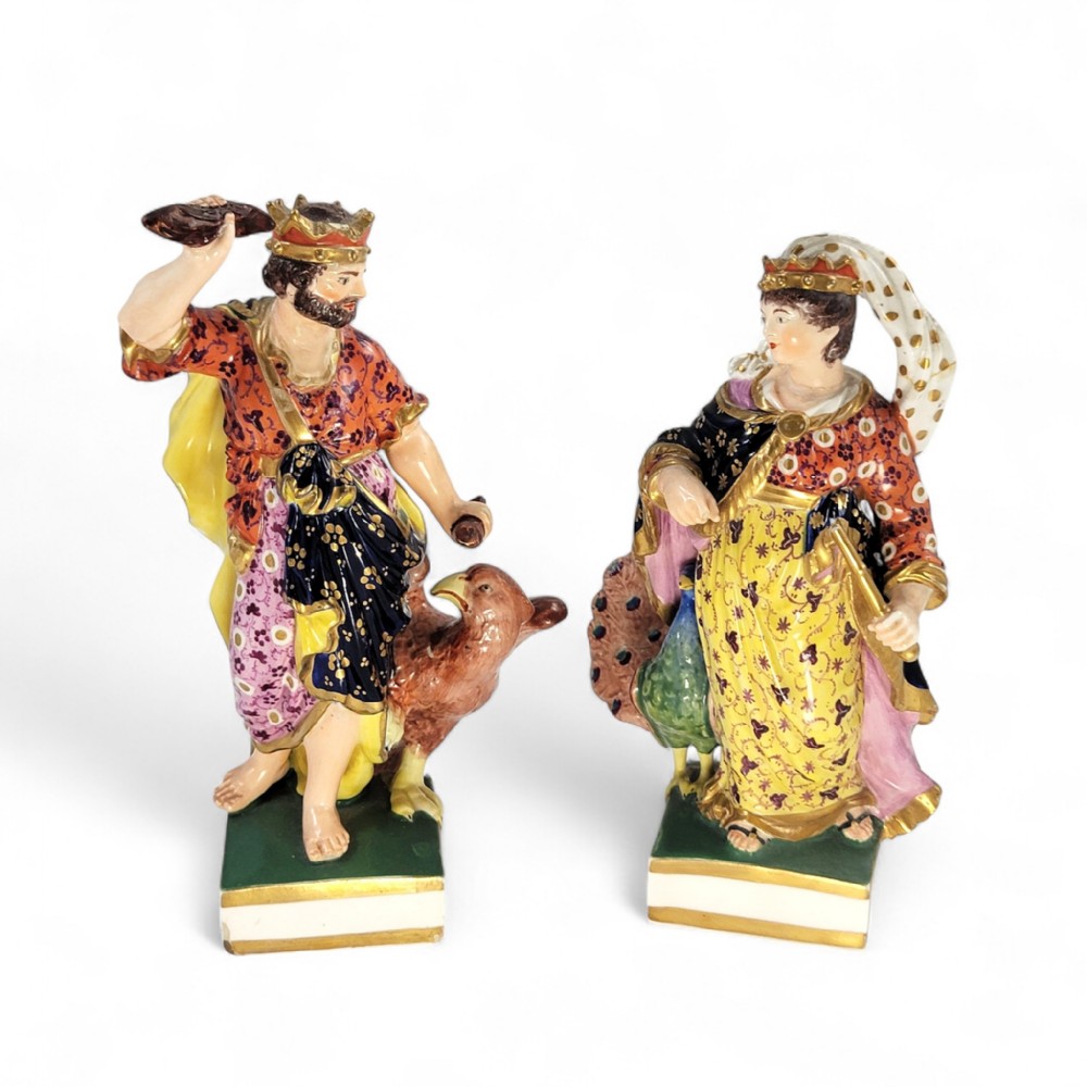 A pair of Bloor Derby porcelain figures representing the classical deities Jupiter with an eagle and Juno with a peacock, decorated in polychrome enamels with gilding.