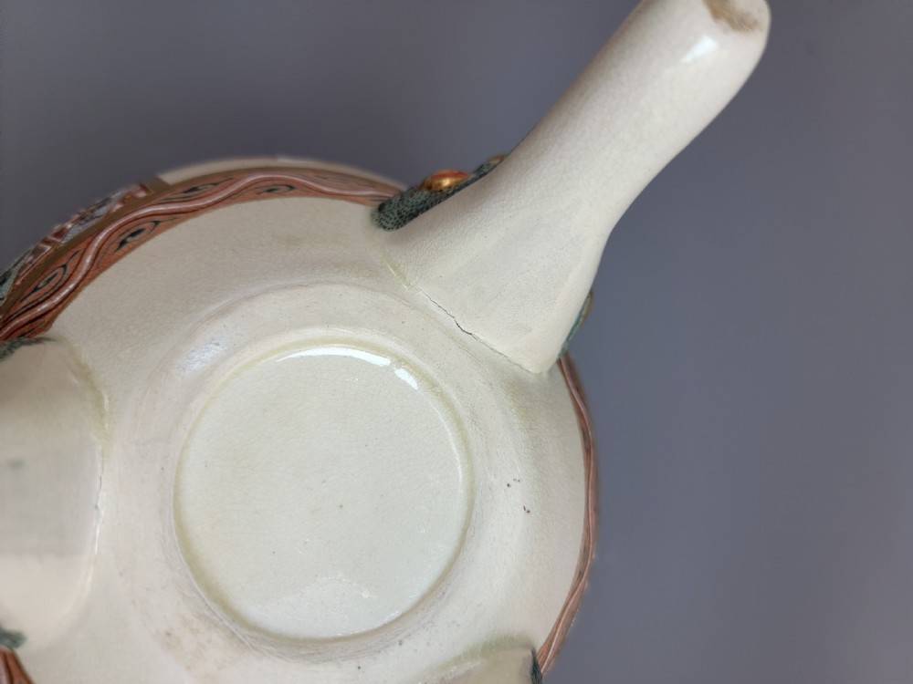 A cream-coloured Japanese Satsuma earthenware incense burner featuring a lid with a shishi lion finial, upright handles, tripod feet, and detailed polychrome paintings of samurai warriors with gold accents. View XVI