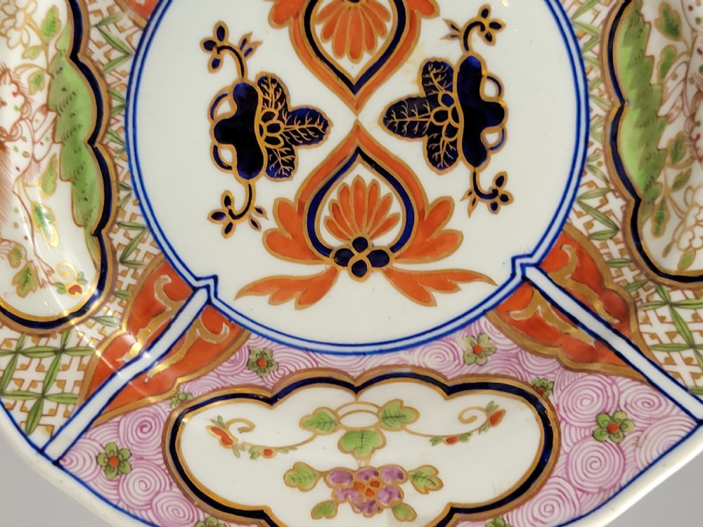 A pair of circular late 18th-century Derby porcelain plates featuring scalloped rims and hand-painted polychrome Kylin pattern designs in orange, cobalt blue, pink, and green. View VI