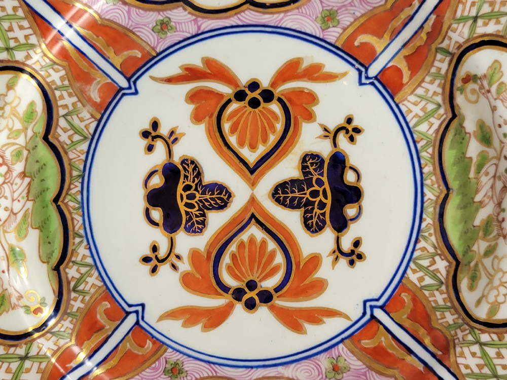 A pair of circular late 18th-century Derby porcelain plates featuring scalloped rims and hand-painted polychrome Kylin pattern designs in orange, cobalt blue, pink, and green. View VII