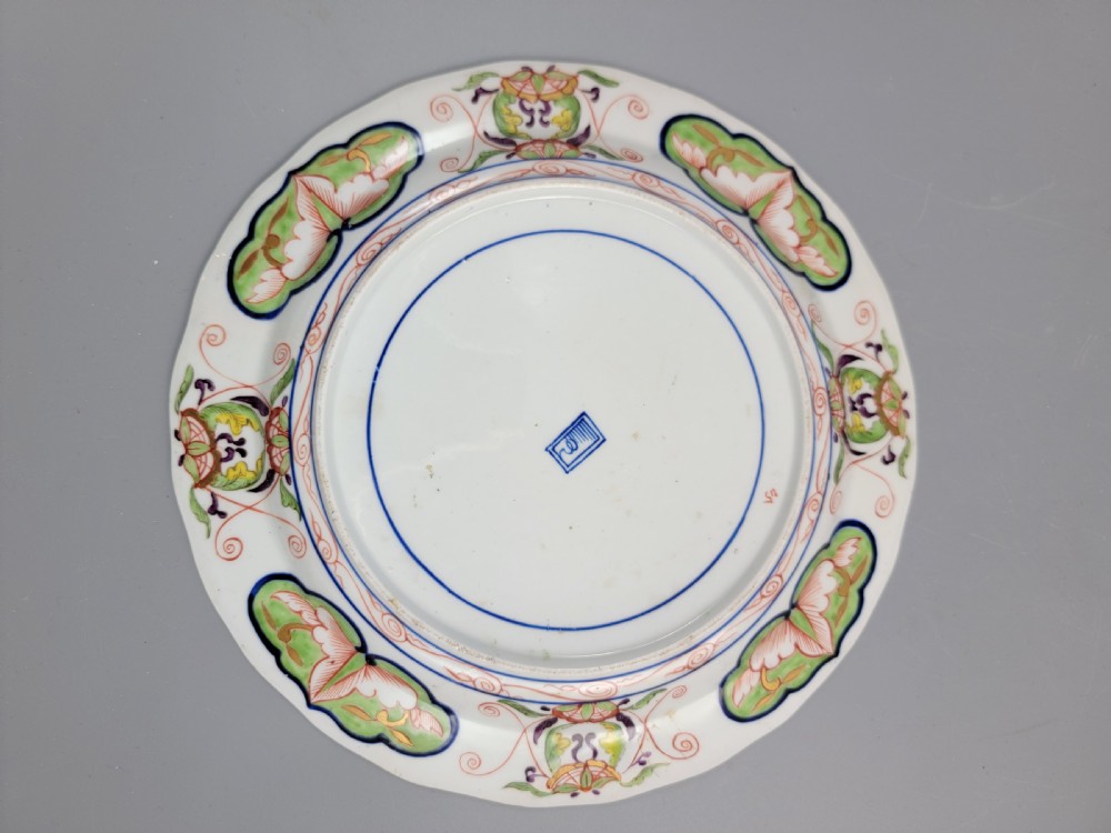 A pair of circular late 18th-century Derby porcelain plates featuring scalloped rims and hand-painted polychrome Kylin pattern designs in orange, cobalt blue, pink, and green. View IX