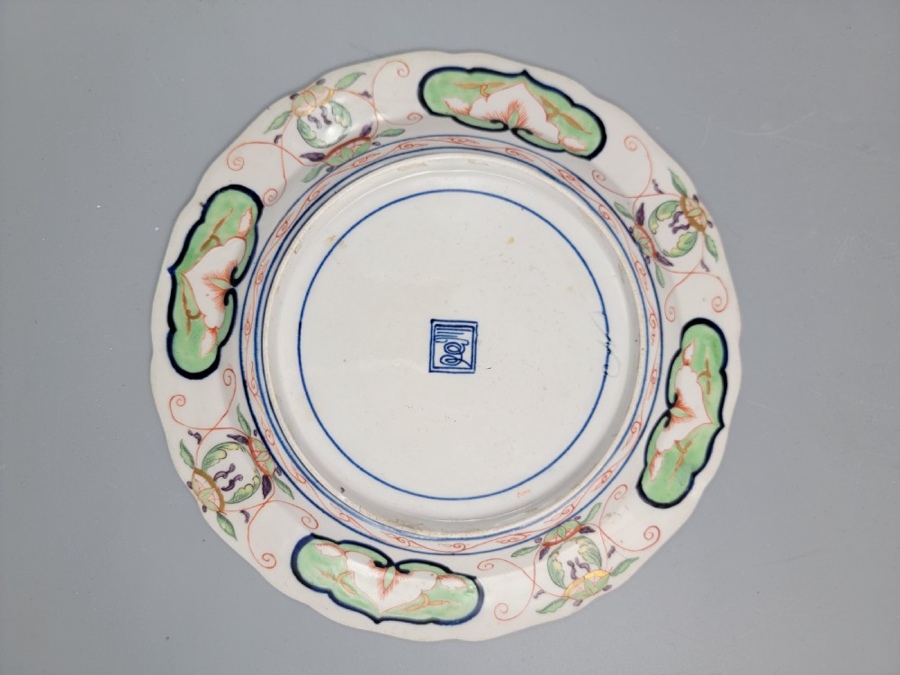 A pair of circular late 18th-century Derby porcelain plates featuring scalloped rims and hand-painted polychrome Kylin pattern designs in orange, cobalt blue, pink, and green. View XIV