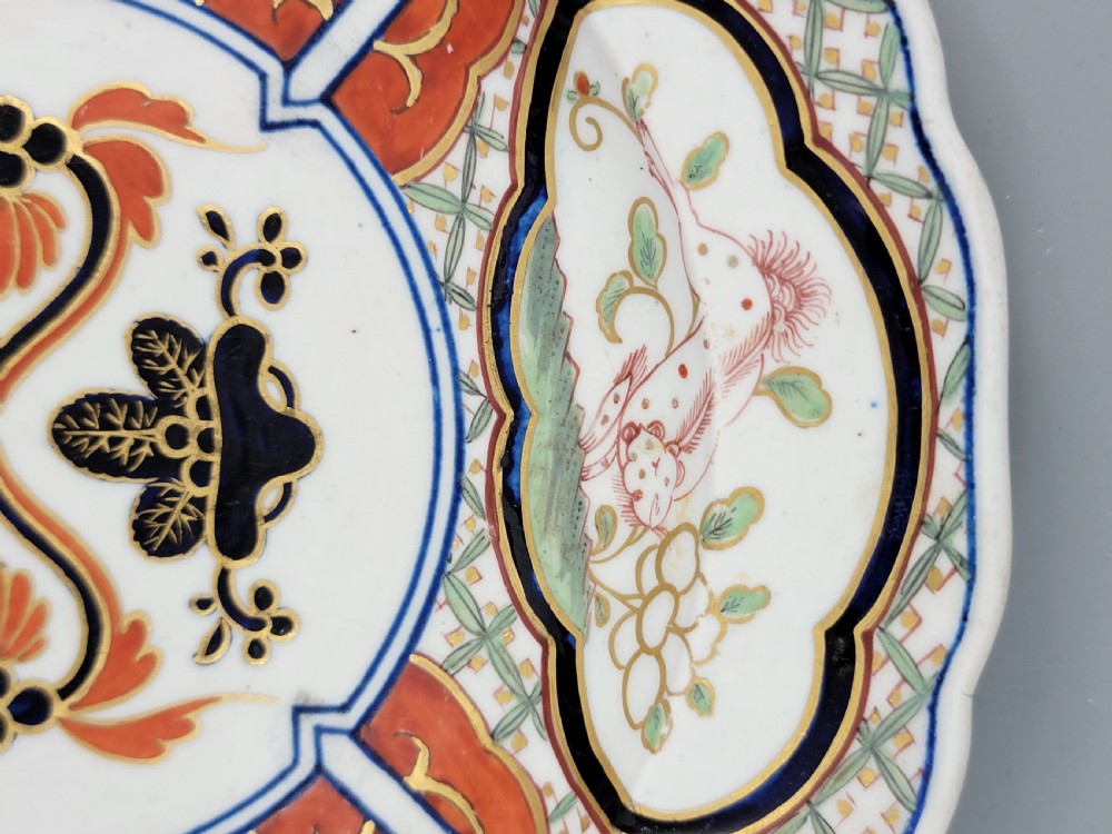 A pair of circular late 18th-century Derby porcelain plates featuring scalloped rims and hand-painted polychrome Kylin pattern designs in orange, cobalt blue, pink, and green. View XVIII