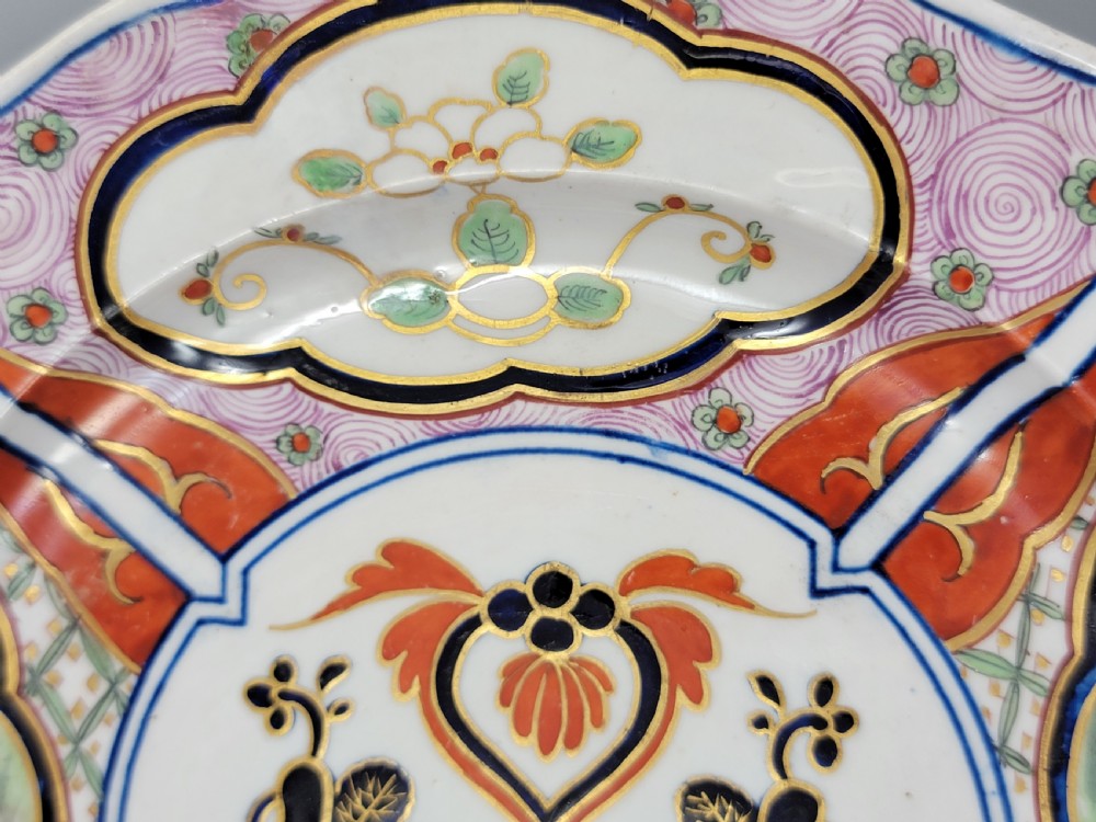 A pair of circular late 18th-century Derby porcelain plates featuring scalloped rims and hand-painted polychrome Kylin pattern designs in orange, cobalt blue, pink, and green. View XIX