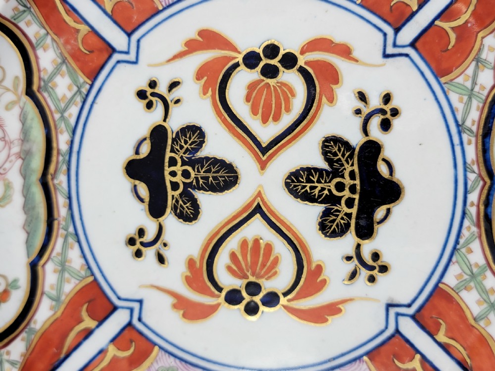 A pair of circular late 18th-century Derby porcelain plates featuring scalloped rims and hand-painted polychrome Kylin pattern designs in orange, cobalt blue, pink, and green. View XX