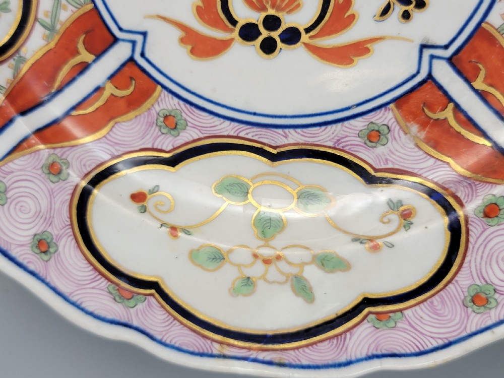 A pair of circular late 18th-century Derby porcelain plates featuring scalloped rims and hand-painted polychrome Kylin pattern designs in orange, cobalt blue, pink, and green. View XXI