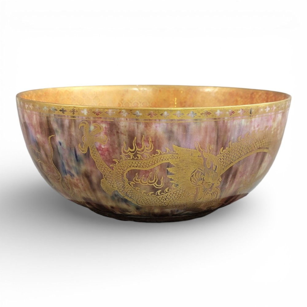 A circular ceramic bowl featuring a mottled pink and purple iridescent lustre glaze adorned with detailed gilded dragon motifs.