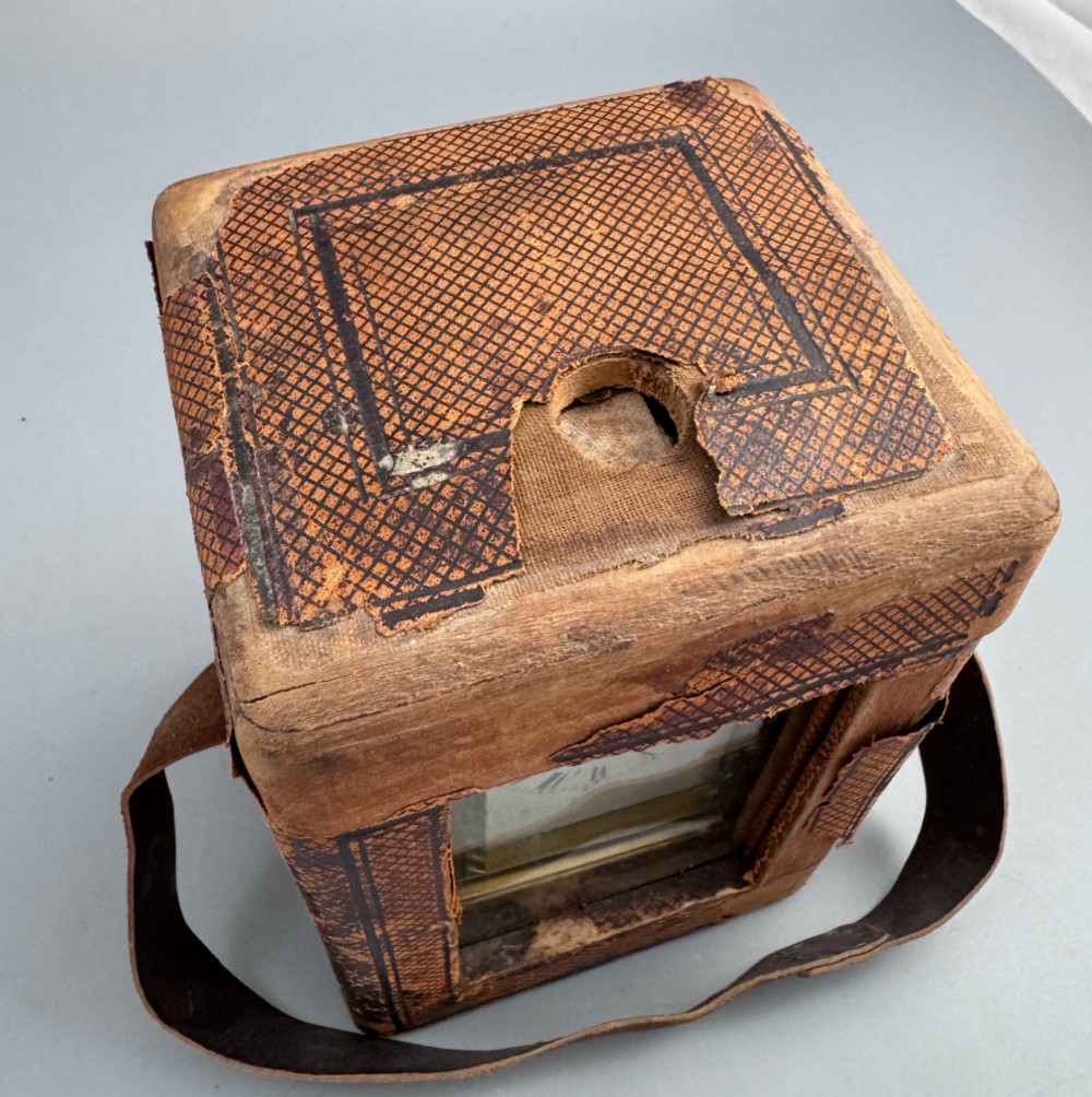 A late 19th-century French brass carriage clock housed inside a protective, textured brown leather travelling case with a leather carrying strap. View II