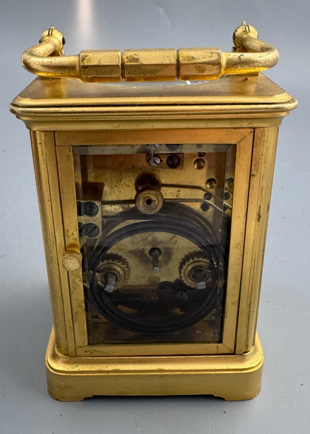 A late 19th-century French brass carriage clock housed inside a protective, textured brown leather travelling case with a leather carrying strap. View V