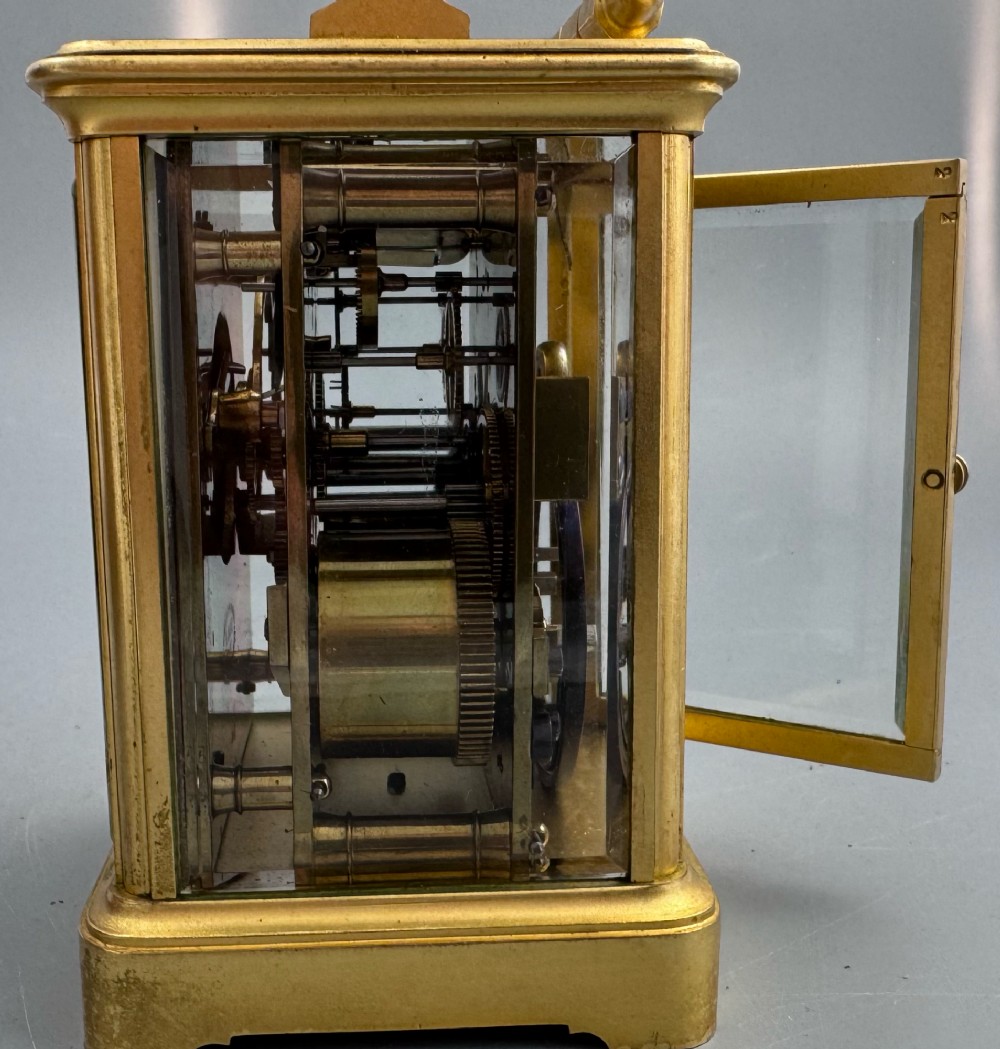 A late 19th-century French brass carriage clock housed inside a protective, textured brown leather travelling case with a leather carrying strap. View VIII