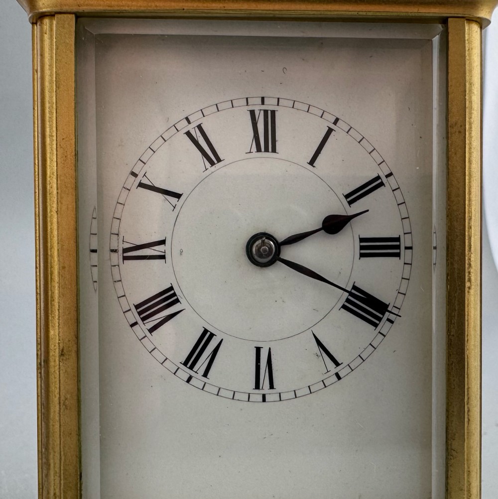A late 19th-century French brass carriage clock housed inside a protective, textured brown leather travelling case with a leather carrying strap. View IX