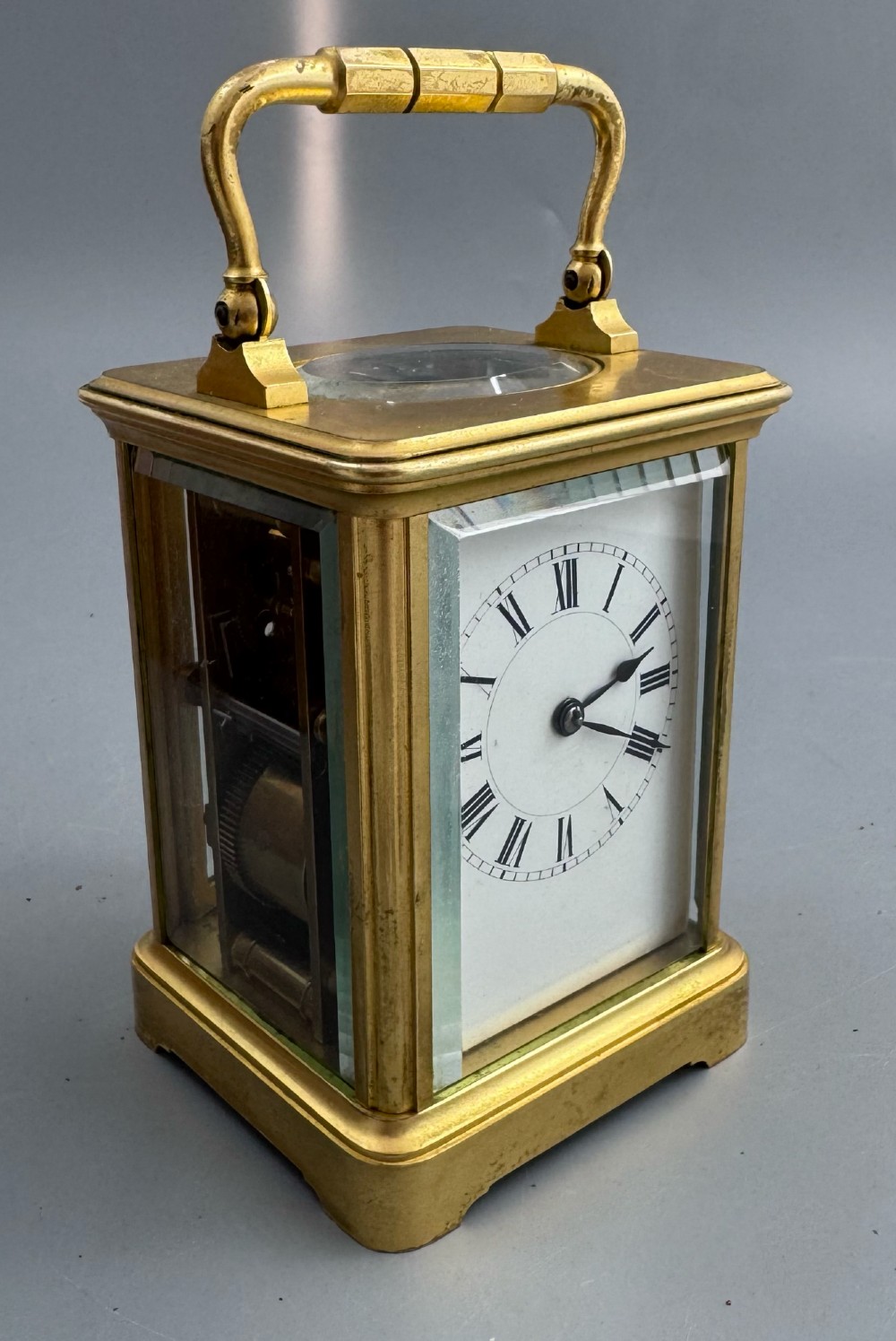 A late 19th-century French brass carriage clock housed inside a protective, textured brown leather travelling case with a leather carrying strap. View X