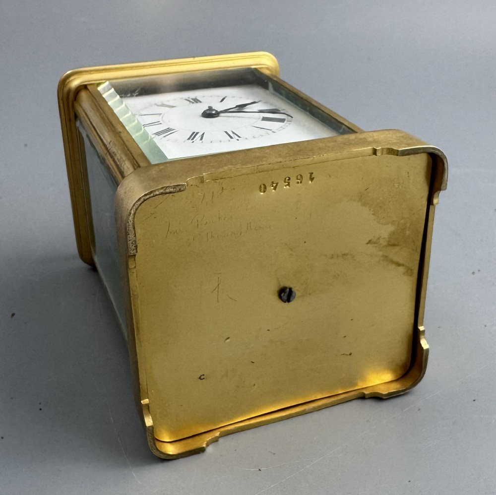 A late 19th-century French brass carriage clock housed inside a protective, textured brown leather travelling case with a leather carrying strap. View XI
