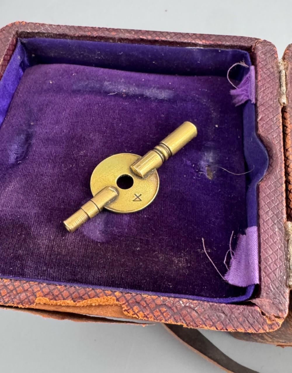 A late 19th-century French brass carriage clock housed inside a protective, textured brown leather travelling case with a leather carrying strap. View XII