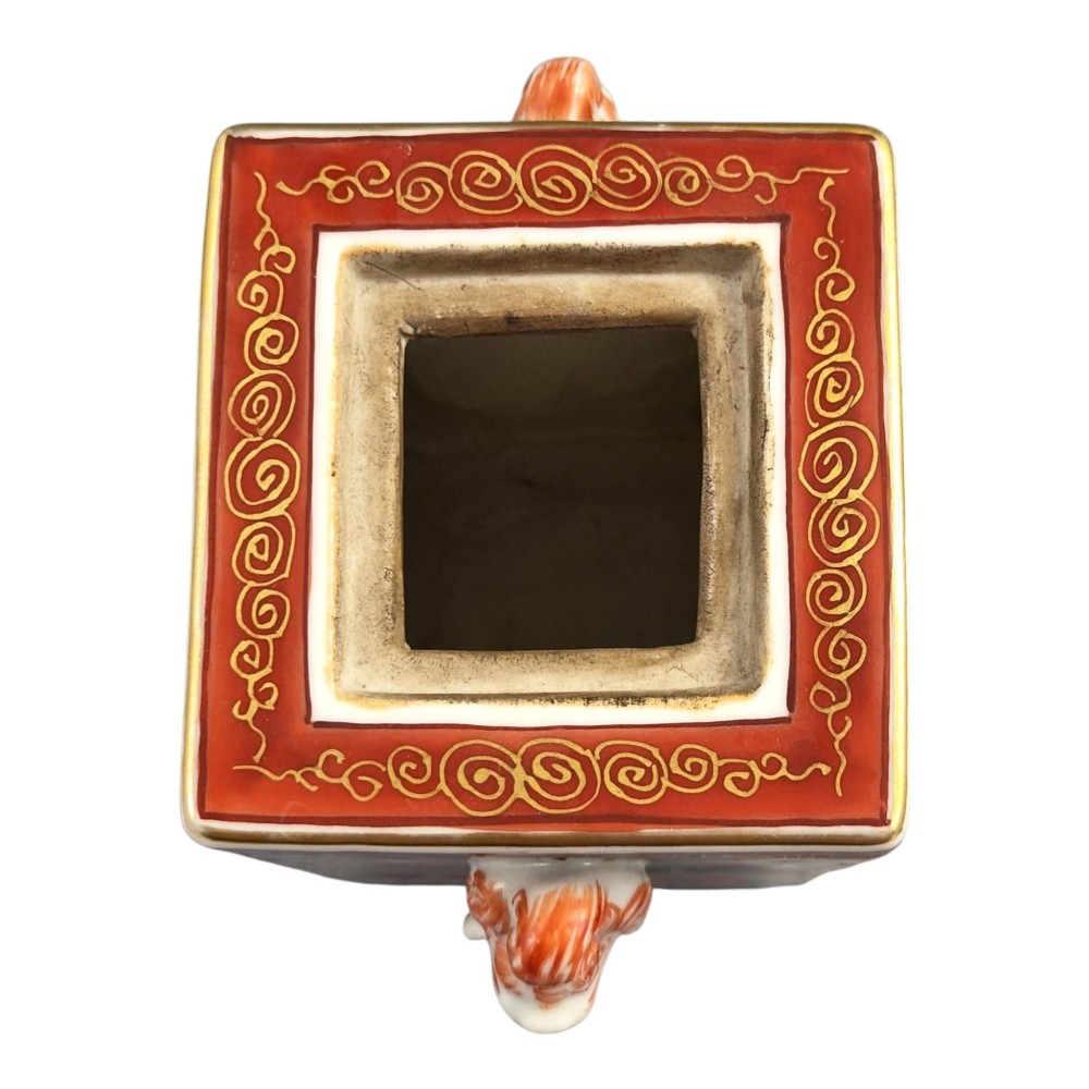 A rectangular Japanese porcelain incense burner featuring hand-painted depictions of a European ship, decorative red enamel borders, animal head handles, and a shishi lion finial on the lid. View VIII