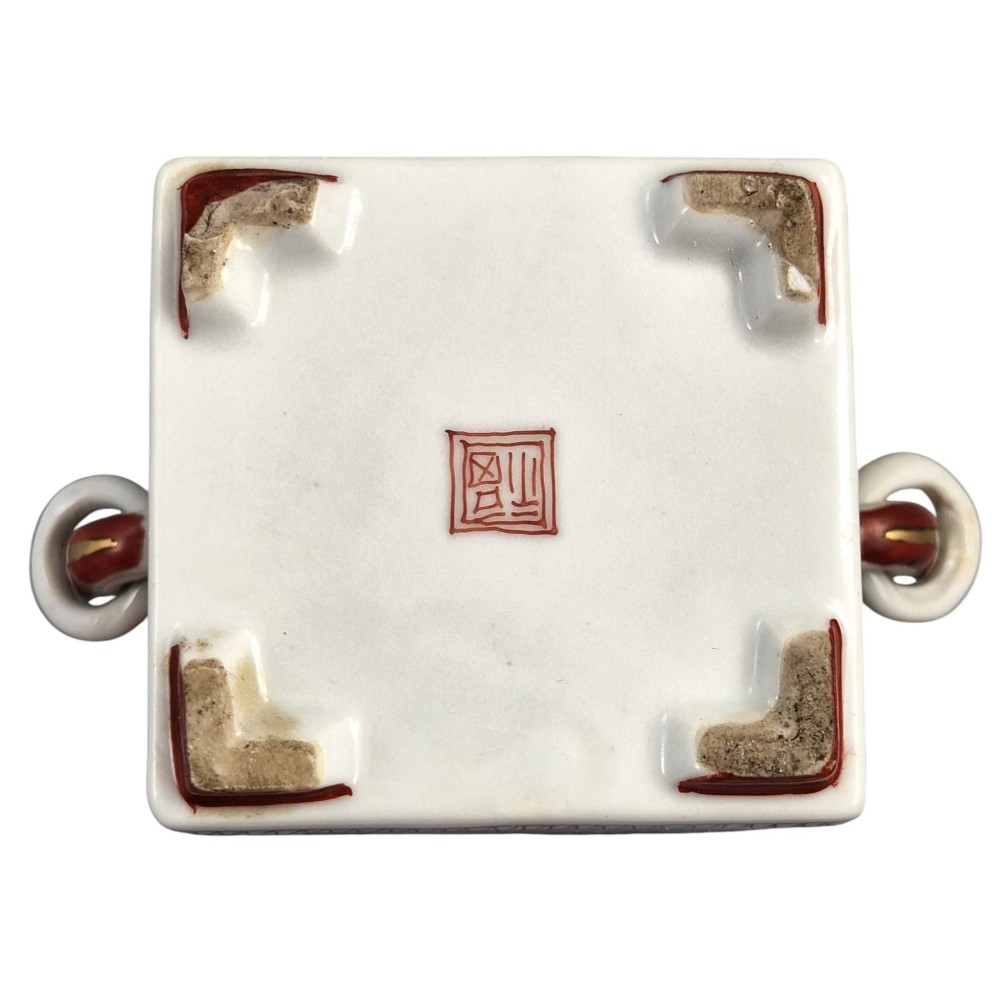 A rectangular Japanese porcelain incense burner featuring hand-painted depictions of a European ship, decorative red enamel borders, animal head handles, and a shishi lion finial on the lid. View XI