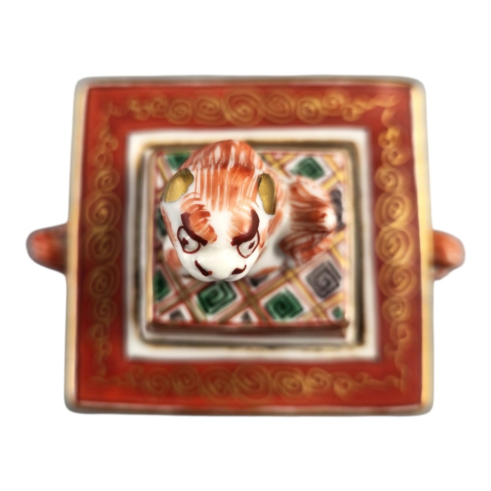A rectangular Japanese porcelain incense burner featuring hand-painted depictions of a European ship, decorative red enamel borders, animal head handles, and a shishi lion finial on the lid. View XIII