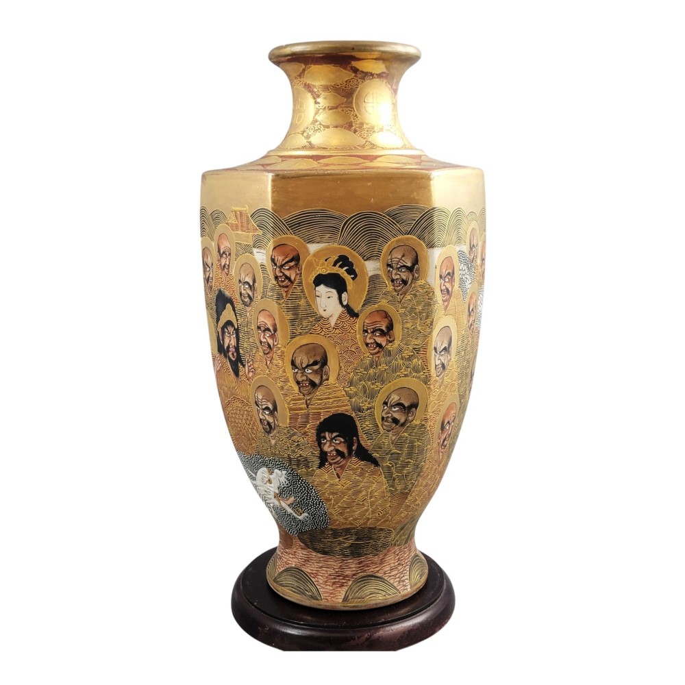 A tall gilded Japanese Satsuma earthenware vase painted with figures of Arhats and a dragon, set on a dark wooden base. View II