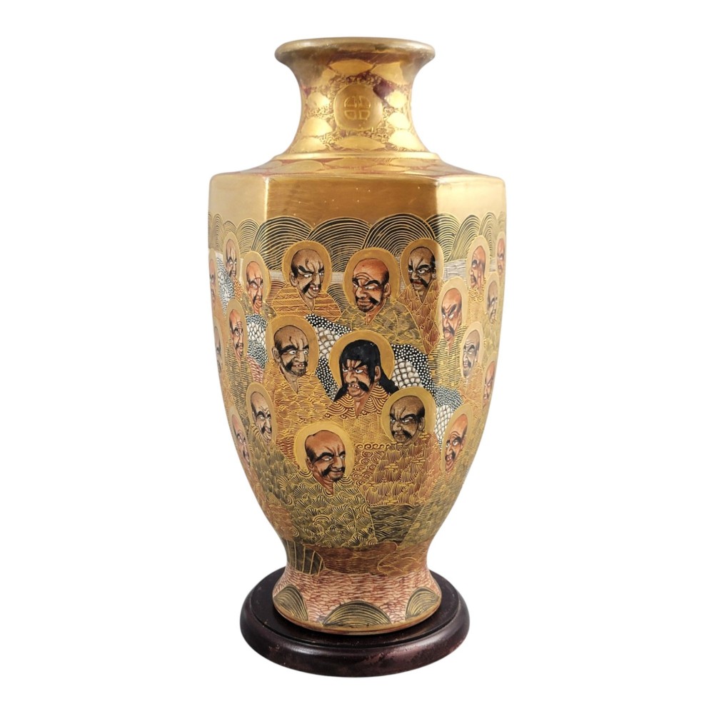 A tall gilded Japanese Satsuma earthenware vase painted with figures of Arhats and a dragon, set on a dark wooden base. View IV