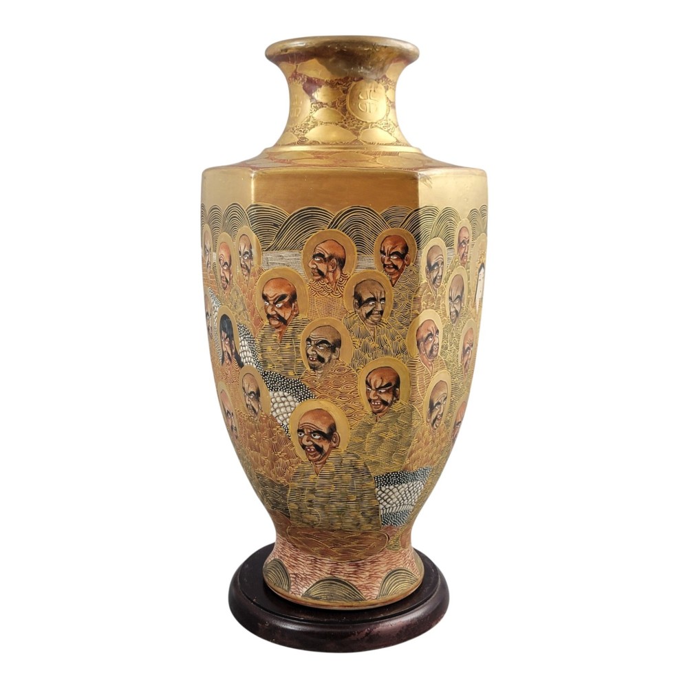 A tall gilded Japanese Satsuma earthenware vase painted with figures of Arhats and a dragon, set on a dark wooden base. View V