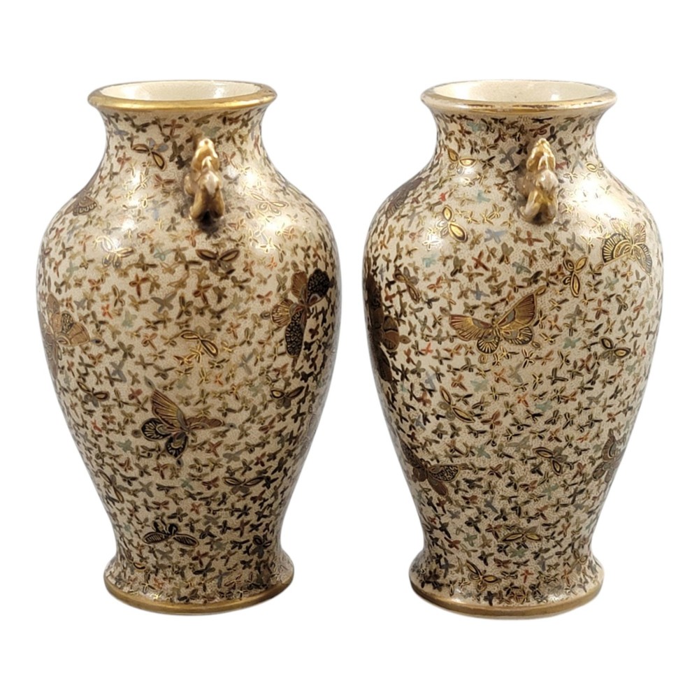 A pair of baluster-shaped Japanese Satsuma earthenware vases decorated with a dense pattern of polychrome butterflies and gold lion-dog side handles. View X