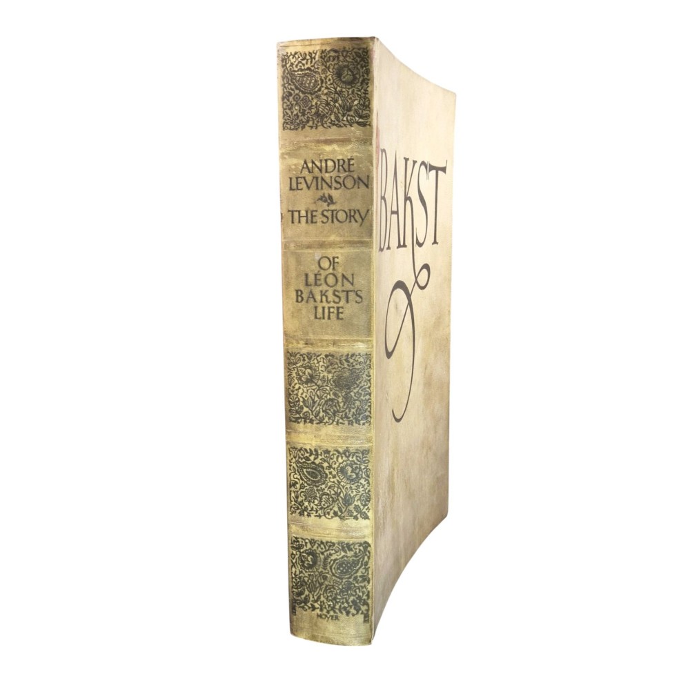 The spine of an antique hardcover book featuring intricate gilt floral patterns and lettered text reading The Story of Leon Baksts Life by Andre Levinson. View IV