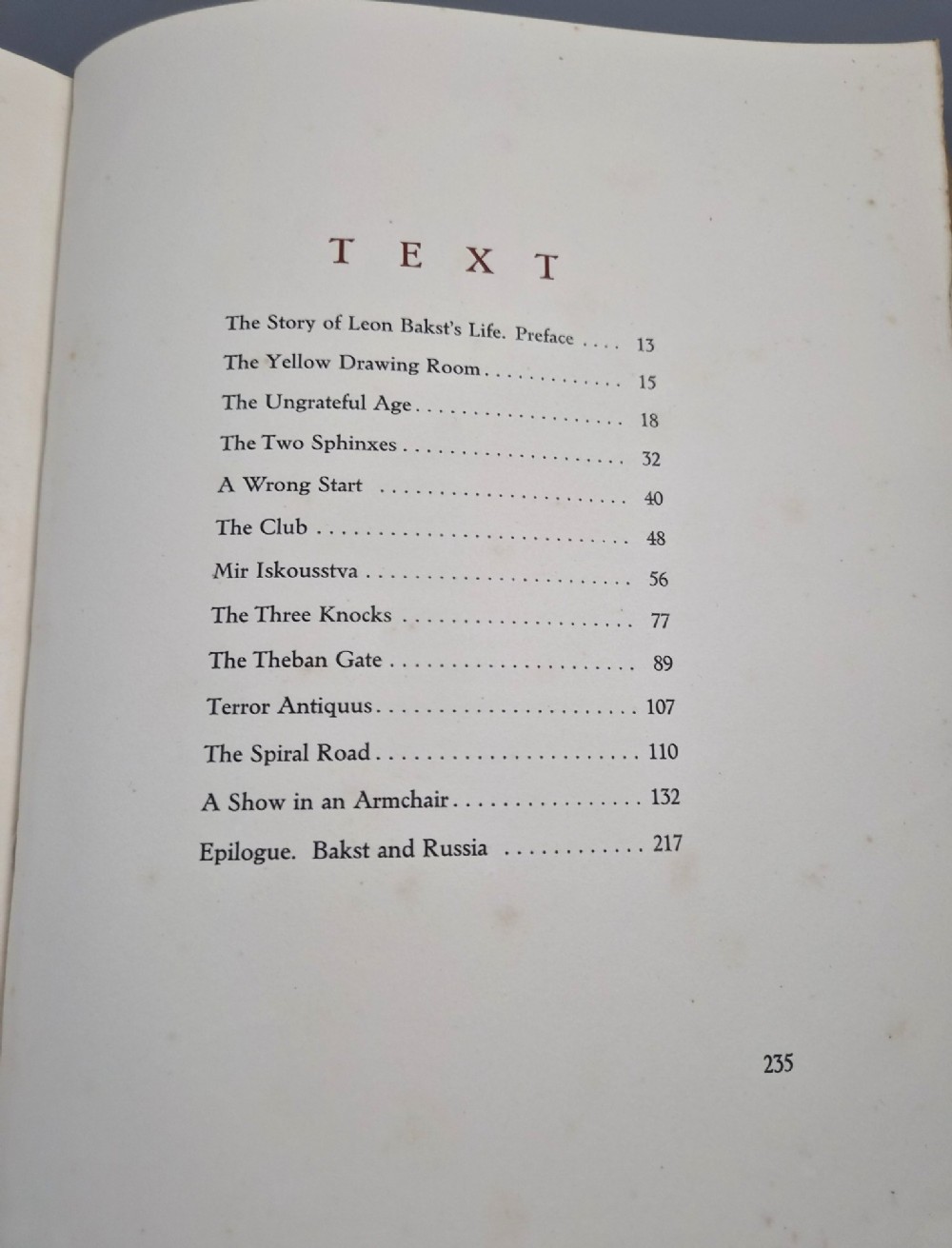 The spine of an antique hardcover book featuring intricate gilt floral patterns and lettered text reading The Story of Leon Baksts Life by Andre Levinson. View XIV