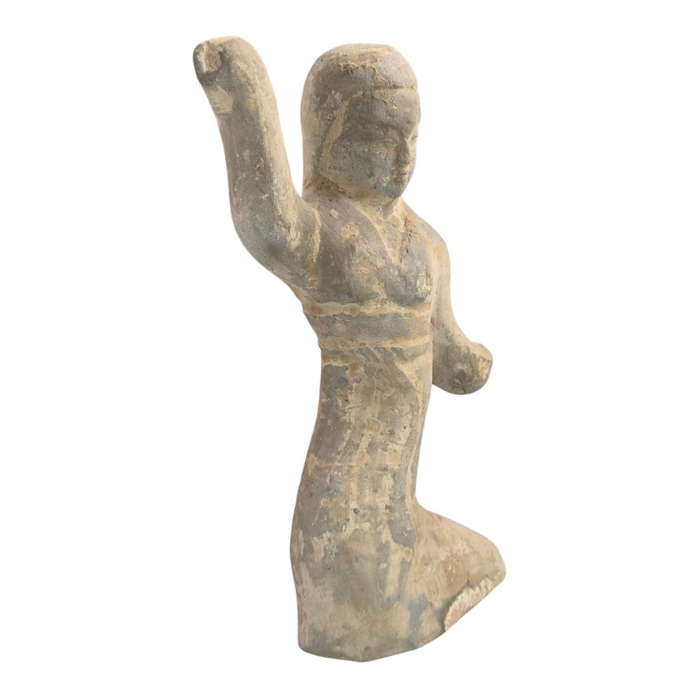 An ancient grey earthenware figure of a dancer in an S-shaped posture with one arm raised and an unglazed finish. View VI