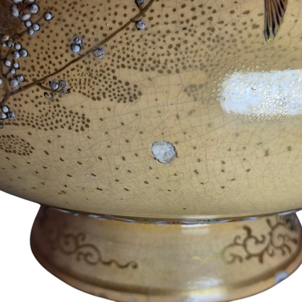 A bulbous Japanese Satsuma earthenware vase featuring a cream crackle glaze, intricate floral gilding, birds, and a carved dark wooden display stand. View VI
