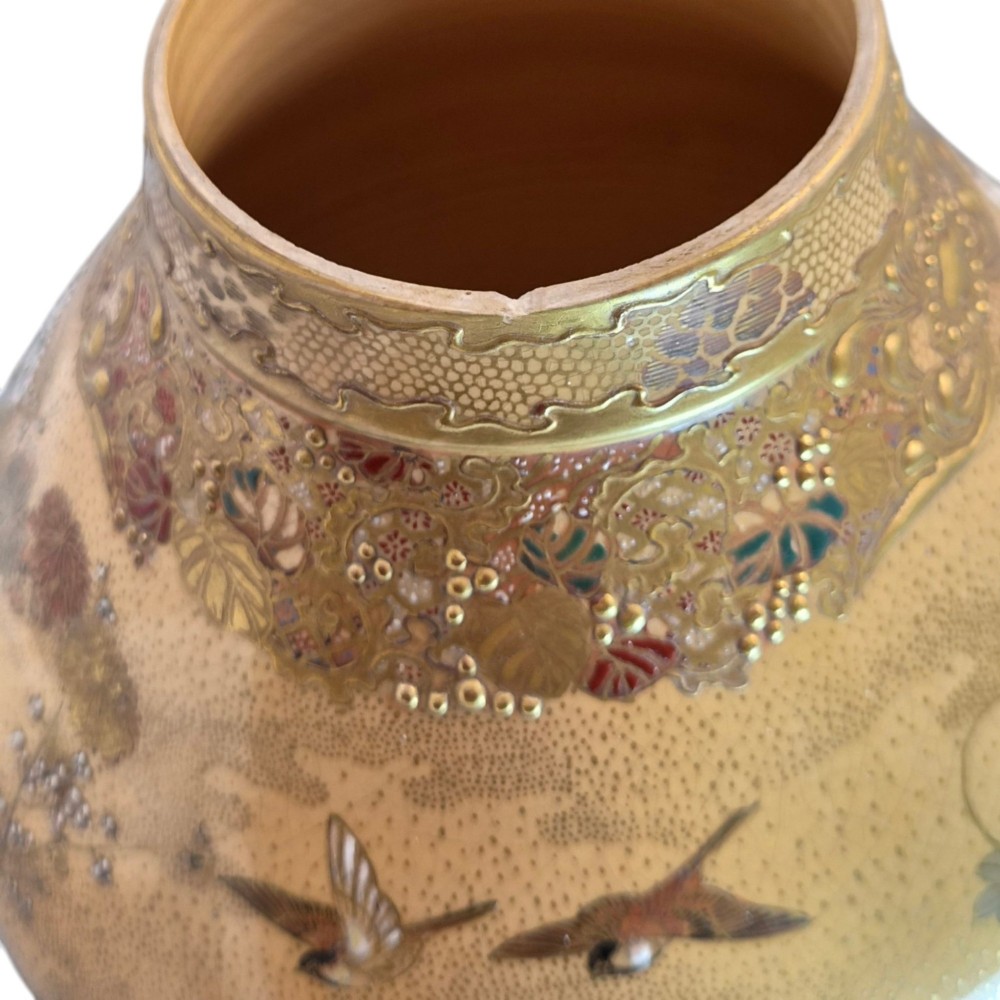 A bulbous Japanese Satsuma earthenware vase featuring a cream crackle glaze, intricate floral gilding, birds, and a carved dark wooden display stand. View XV