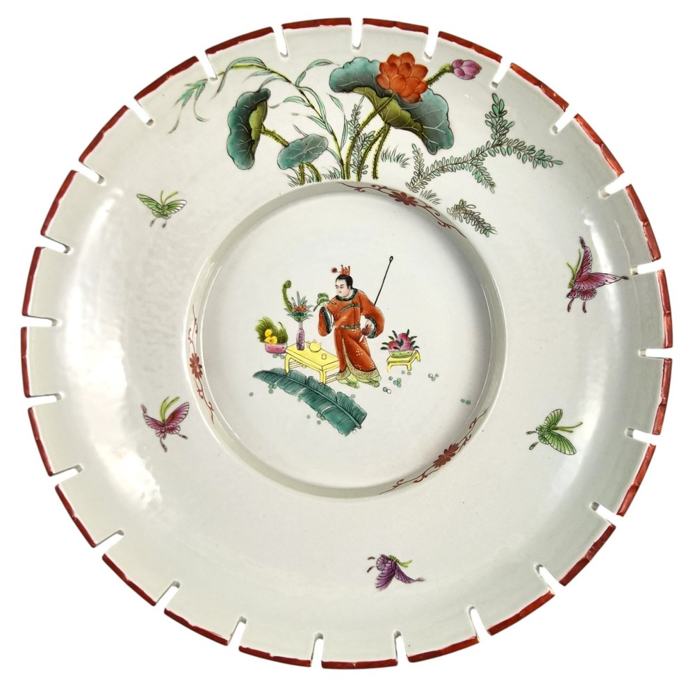 A late Qing dynasty Chinese Famille Rose porcelain dish featuring a hand-painted central figure, lotus blossoms, butterflies, and a distinct red castellated rim. View VI
