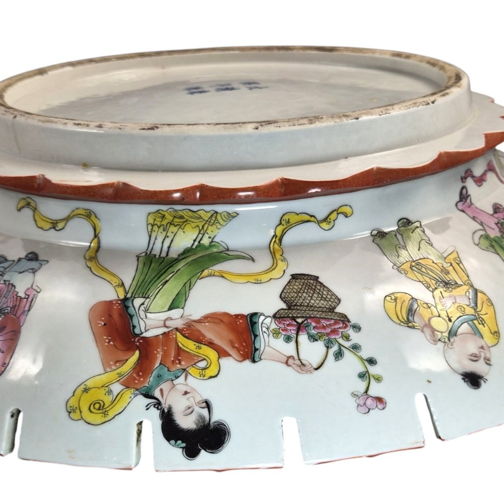 A late Qing dynasty Chinese Famille Rose porcelain dish featuring a hand-painted central figure, lotus blossoms, butterflies, and a distinct red castellated rim. View IX