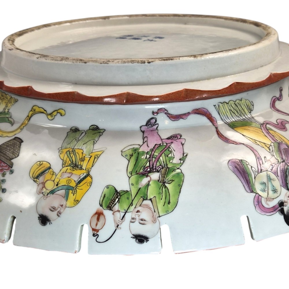 A late Qing dynasty Chinese Famille Rose porcelain dish featuring a hand-painted central figure, lotus blossoms, butterflies, and a distinct red castellated rim. View X