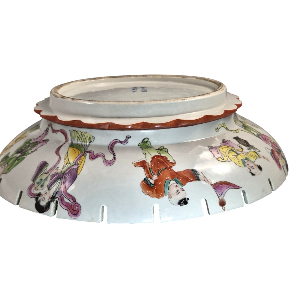 A late Qing dynasty Chinese Famille Rose porcelain dish featuring a hand-painted central figure, lotus blossoms, butterflies, and a distinct red castellated rim. View XI