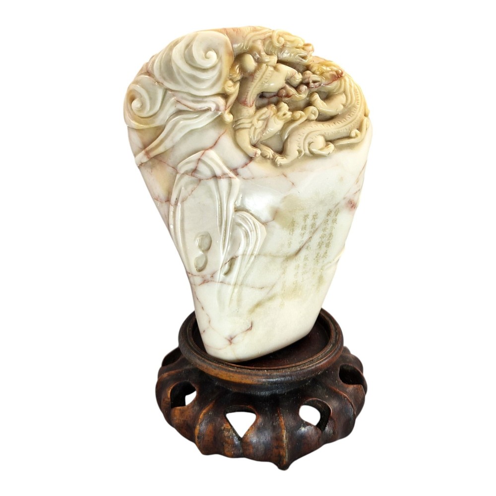 A carved cream and tan Shoushan stone sculpture depicting a dragon amongst clouds set upon a dark turned wooden base. View VII