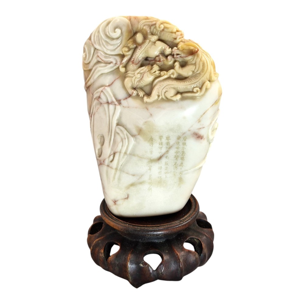 A carved cream and tan Shoushan stone sculpture depicting a dragon amongst clouds set upon a dark turned wooden base. View VIII