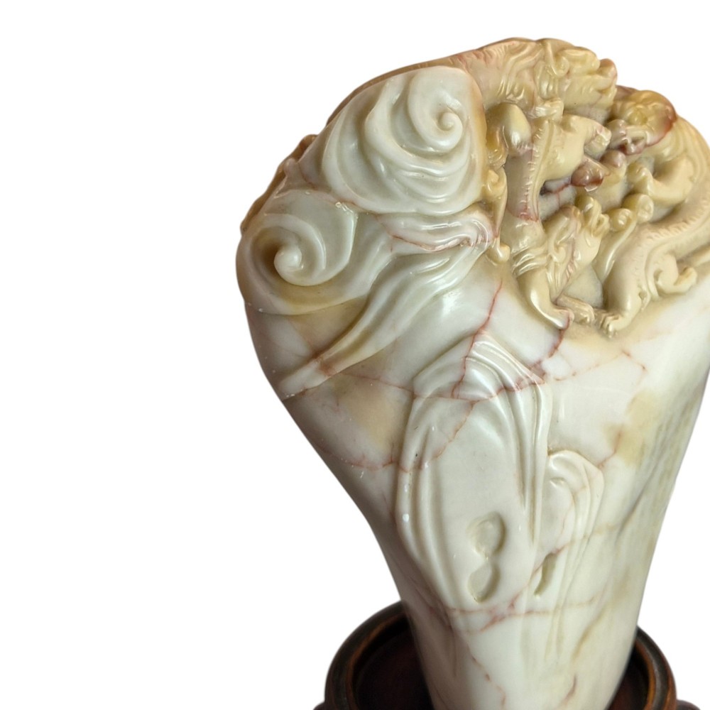 A carved cream and tan Shoushan stone sculpture depicting a dragon amongst clouds set upon a dark turned wooden base. View XII