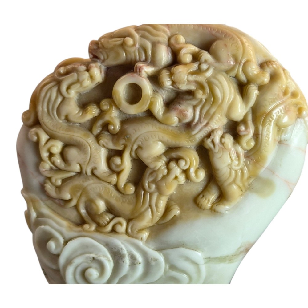 A carved cream and tan Shoushan stone sculpture depicting a dragon amongst clouds set upon a dark turned wooden base. View XIV