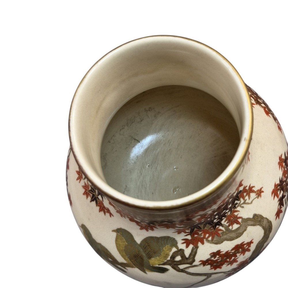 A pair of bulbous cream-coloured Japanese Satsuma earthenware vases decorated with gilt birds and autumnal foliage on dark carved wood stands. View V