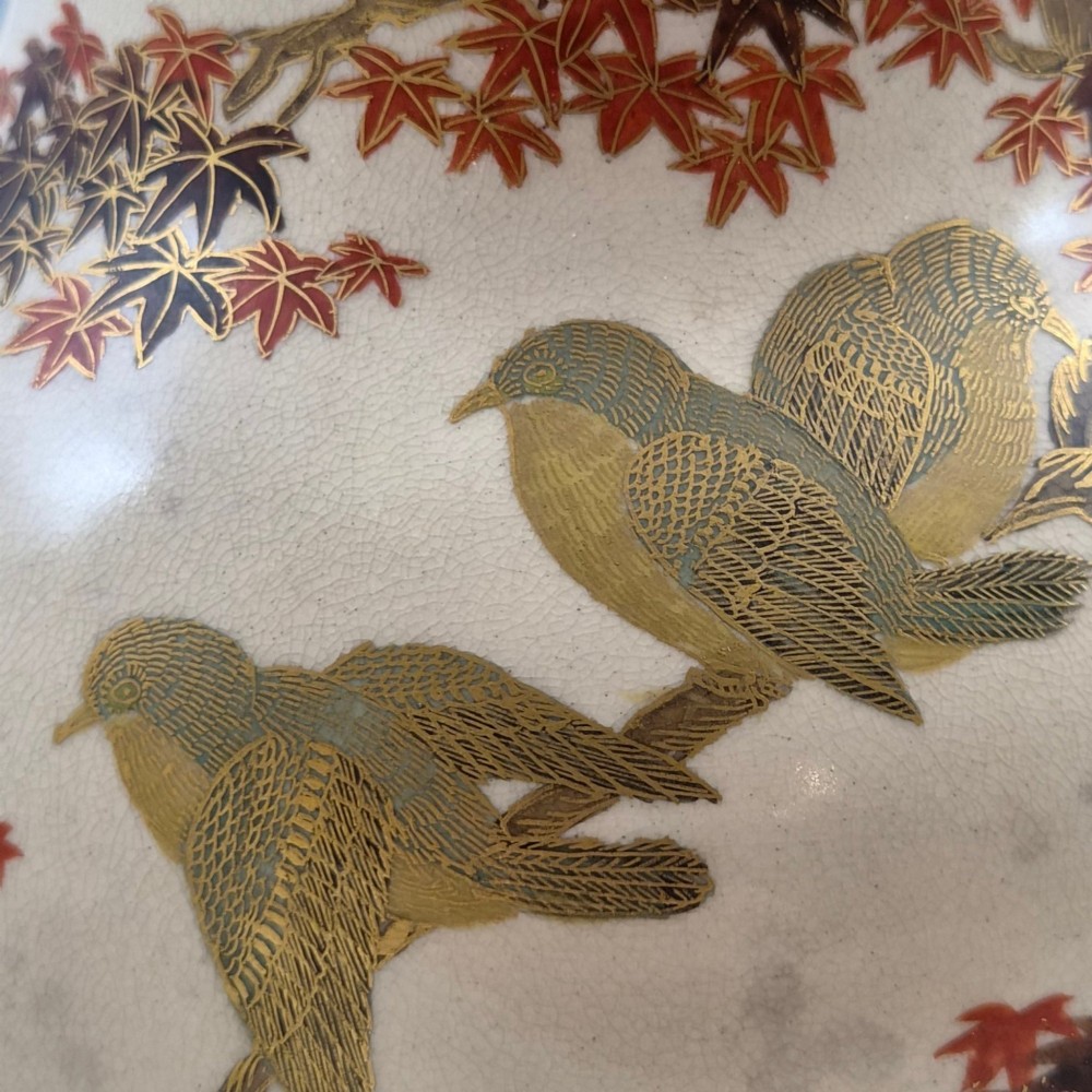 A pair of bulbous cream-coloured Japanese Satsuma earthenware vases decorated with gilt birds and autumnal foliage on dark carved wood stands. View XII