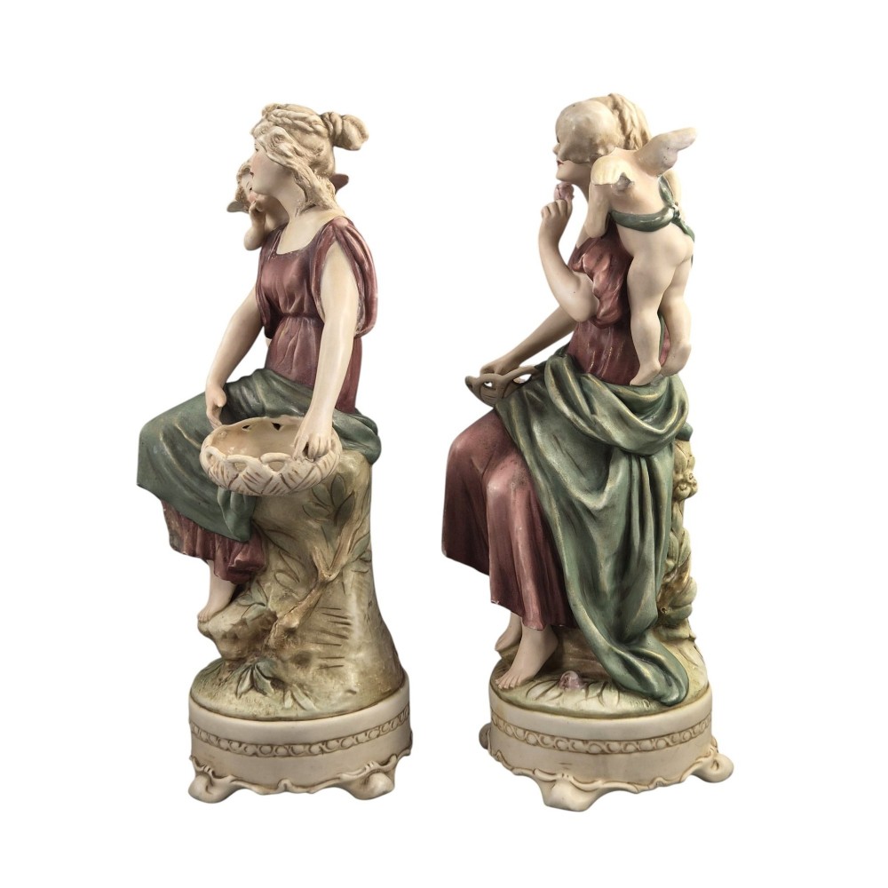 A pair of Royal Dux Art Nouveau porcelain figurines depicting classical maidens with winged cherubs and openwork baskets. View II