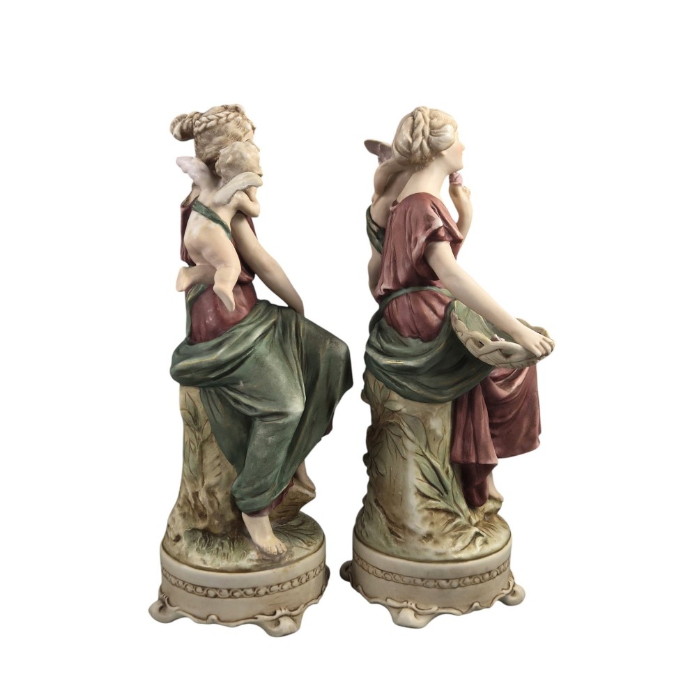A pair of Royal Dux Art Nouveau porcelain figurines depicting classical maidens with winged cherubs and openwork baskets. View IV